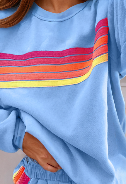 Blue sweatshirt with a colorful stripe design and matching shorts.