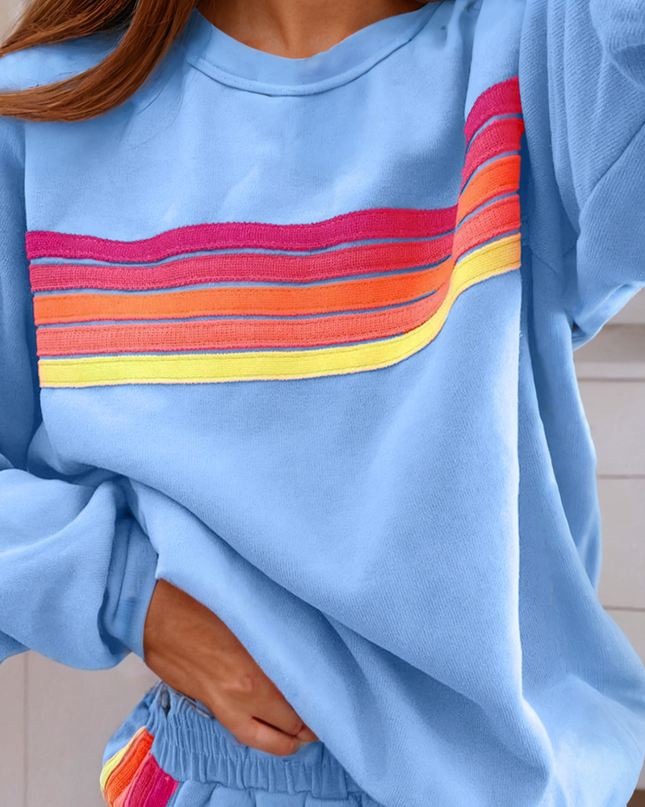 Blue sweatshirt with a colorful stripe design and matching shorts.
